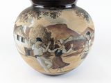 un vase avec un tableau posé sur une table