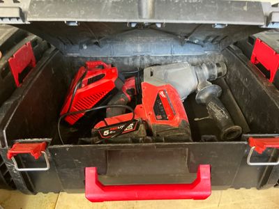 une boîte à outils contenant des outils, posée sur le sol
