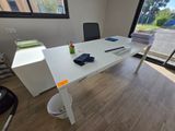 a white desk with a black chair in front of a window