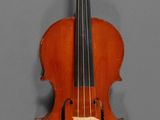an old violin hanging on a wall with a wooden stand
