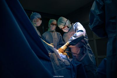 des chirurgiens pratiquant une intervention chirurgicale sur un patient dans un bloc opératoire