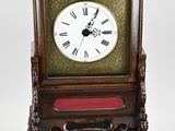 une petite horloge en bois avec des chiffres romains