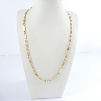 a white mannequin with a gold chain on a white mannequin