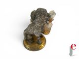 a figurine of a dog on a table next to a vase
