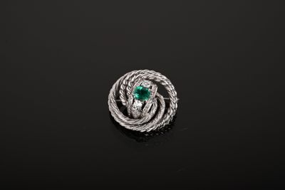 un gros plan d'une bague ornée d'une pierre verte sur un fond noir