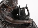 a bronze statue of a woman with a harp