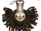a silver and gold brooch on a white background