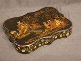 an image of a black and gold box with flowers on it