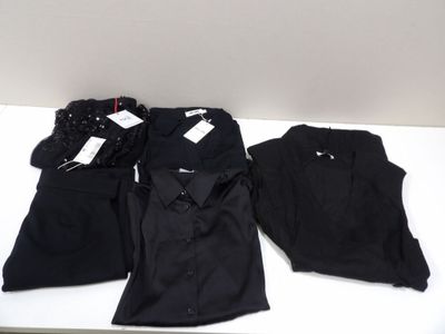 trois paires de chemises et de pantalons noirs posées sur une table blanche