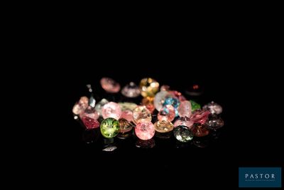 several different colored gems are arranged on a black surface