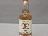 une bouteille de whisky posée sur une table blanche