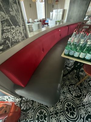 une photo d'un restaurant avec une banquette rouge et noire