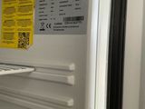 a white refrigerator with its door open and a yellow sticker on the door