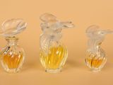 three glass vases with yellow and white flowers on a beige surface