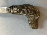 a knife with a dog head on it on a table