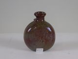 a small brown vase sitting on a white surface