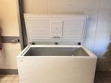 a white chest freezer sitting in the corner of a room