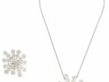un gros plan d'un collier et d'une paire de boucles d'oreilles sur fond blanc
