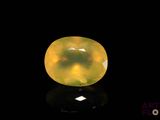 a yellow jade stone on a black surface