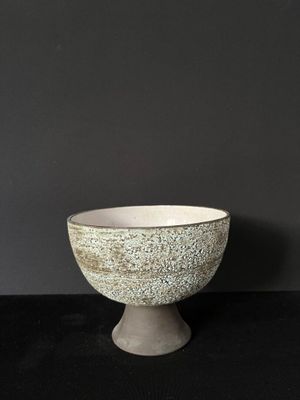 a white bowl sitting on top of a black table