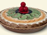 a cake with kiwis and cherries on top of it