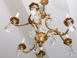 a gold chandelier with crystal drops hanging from the ceiling
