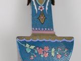 a blue vase on a stand with flowers on it
