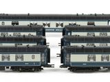 three black and white train cars sitting next to each other on a white surface