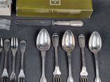a lot of silverware on a table with a green box
