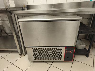 un lave-vaisselle argenté posé sur un plan de travail dans une cuisine
