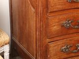 a wooden chest of drawers with a vase on top of it