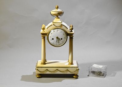 une horloge en or posée sur une table blanche