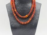 un gros plan d'un collier orné de perles orange sur un mannequin