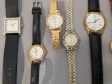 many different types of watches displayed on a table