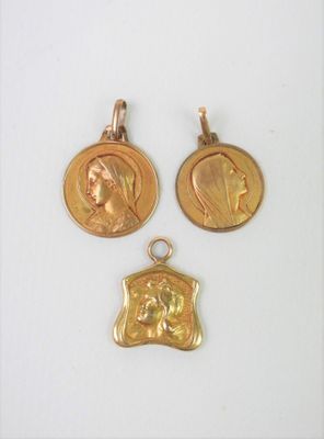 trois médailles d'or représentant une femme et un homme sur un fond blanc