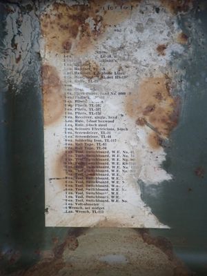 a piece of paper on the side of a rusted metal container