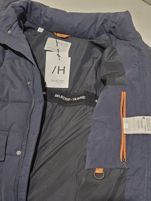une veste bleue avec une étiquette, posée sur une table