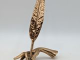 une figurine en laiton représentant une feuille sur une branche