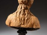 a carved bust of a man with long hair and beard