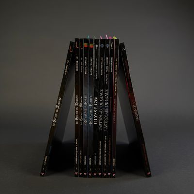 several books stacked on top of each other on a black surface