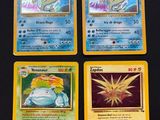 four pokemon cards sitting on top of each other on a table
