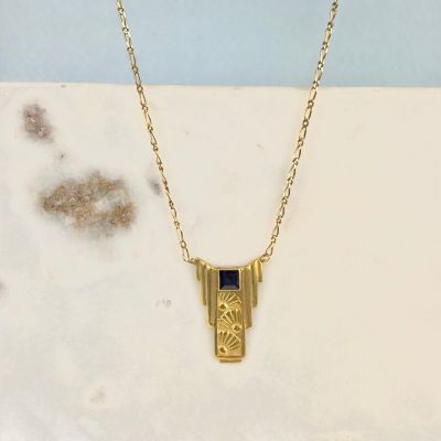un collier plaqué or orné d'un motif géométrique sur une chaîne