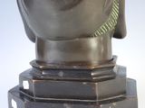 a bronze statue of a buddha head on a pedestal