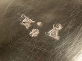 a close up of a silver plate with a design on it