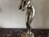 a statue of a woman holding her head in her hands