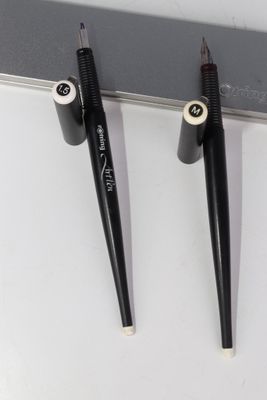 deux stylos sont posés sur une surface blanche