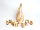 a wooden vase and six cups on a white surface