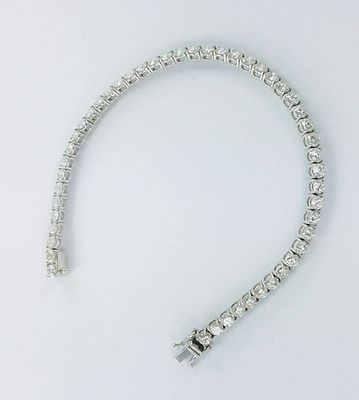 gros plan d'un bracelet en diamant sur une surface blanche