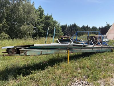 a boat that is sitting on a trailer in the grass