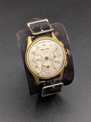 une photo d'une montre-bracelet en or avec un bracelet en cuir noir